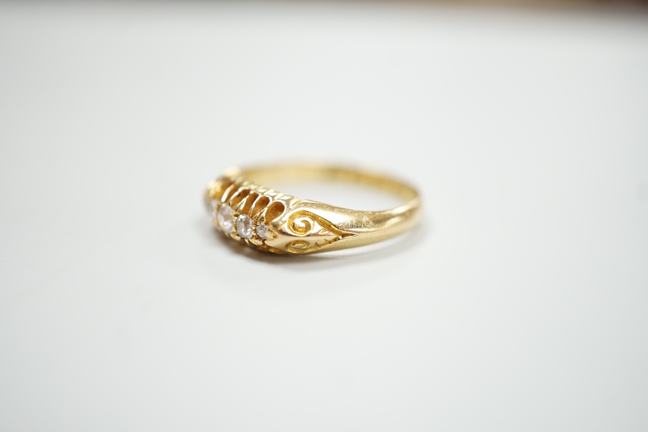 An early 20th century 18ct gold and graduated five stone diamond chip set ring, size L, gross weight 3.6 grams.